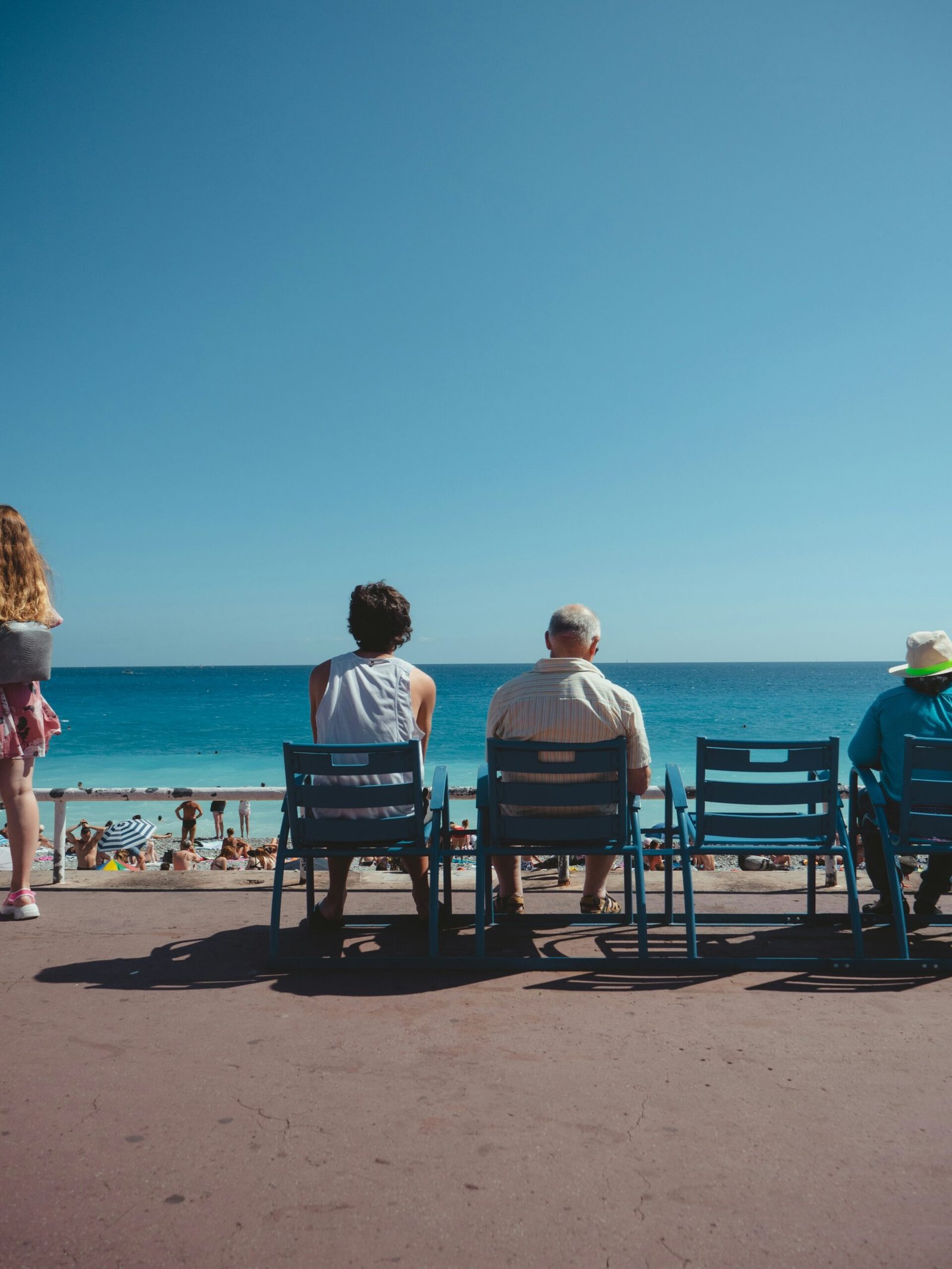 a group of people sitting on top of a beach next to the ocean