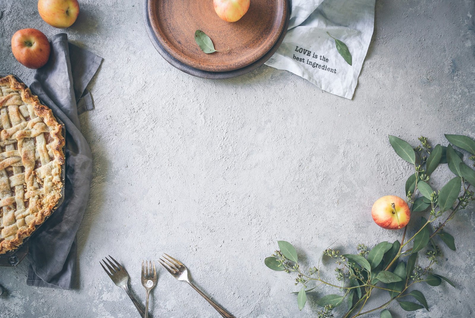 three stainless steel forks near apple