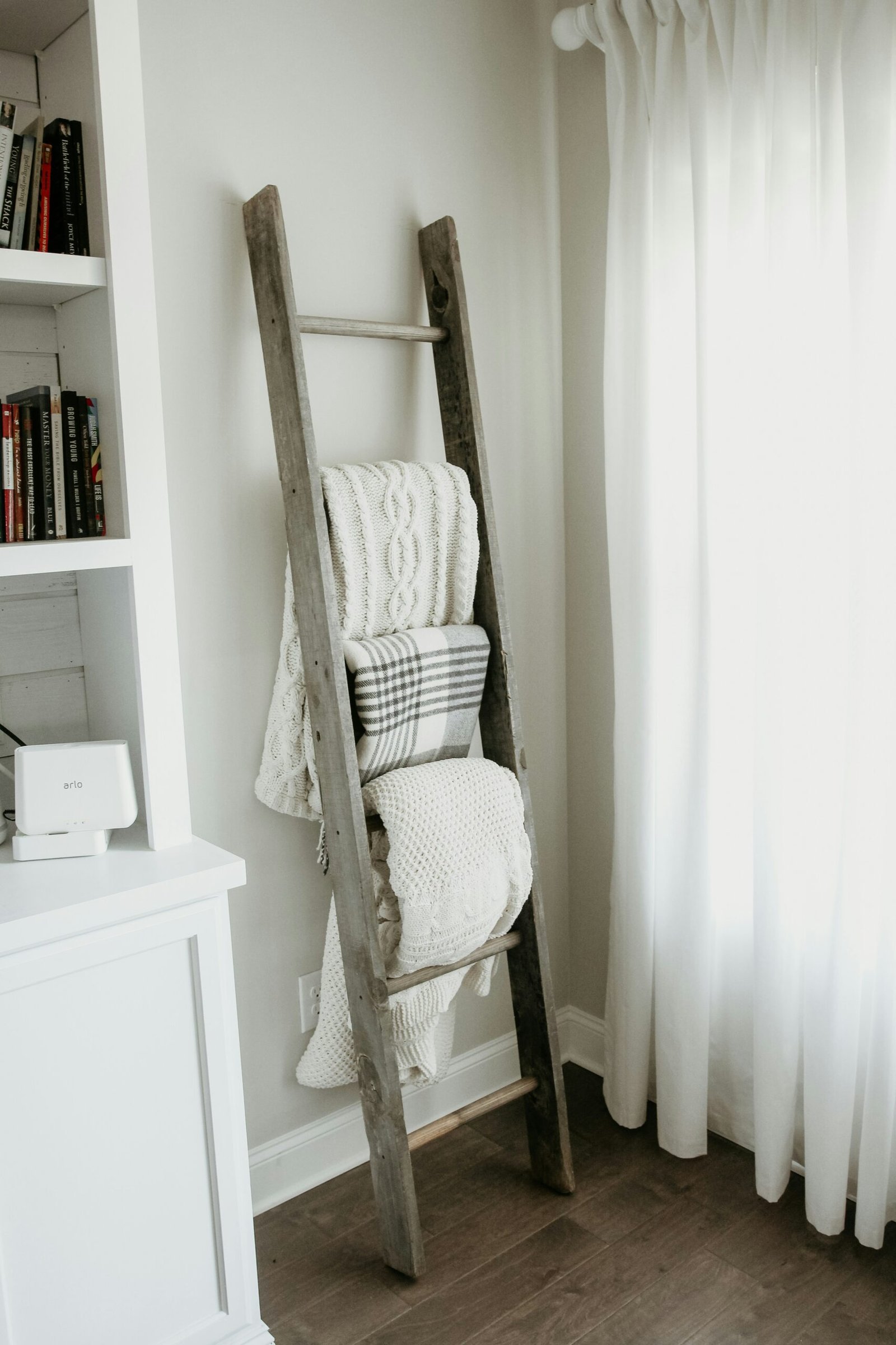 textiles hanging on gray wooden ladder